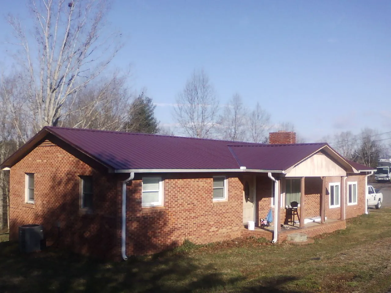Burgundy metal roof on a brick ranch home with a new addition in New Market